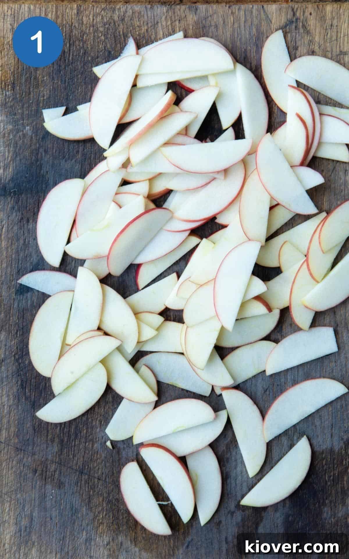 Finely slices apples laid on wooden chopping board.