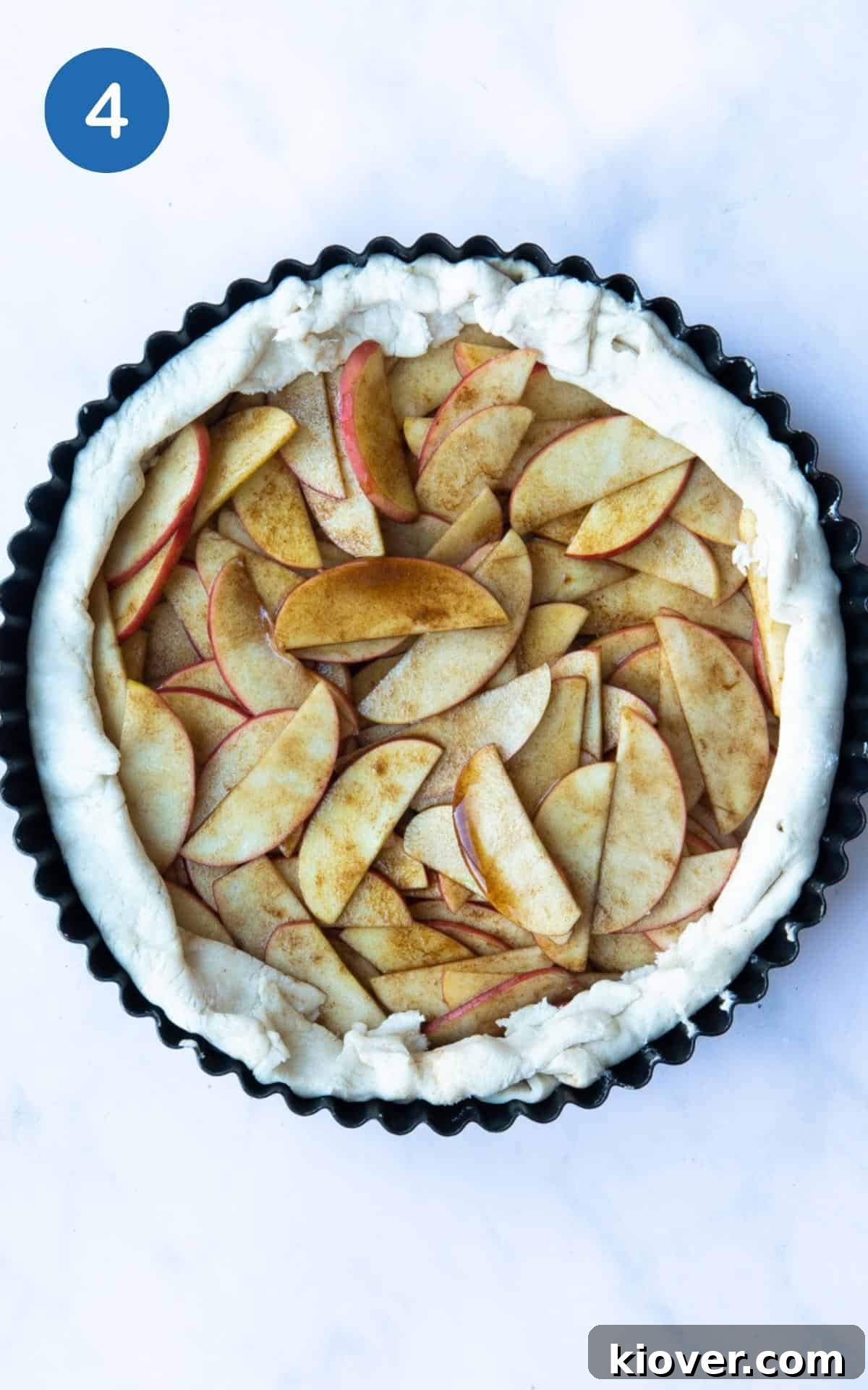 Puff Pastry Apple Tart in a circular fluted tin before being cooked.