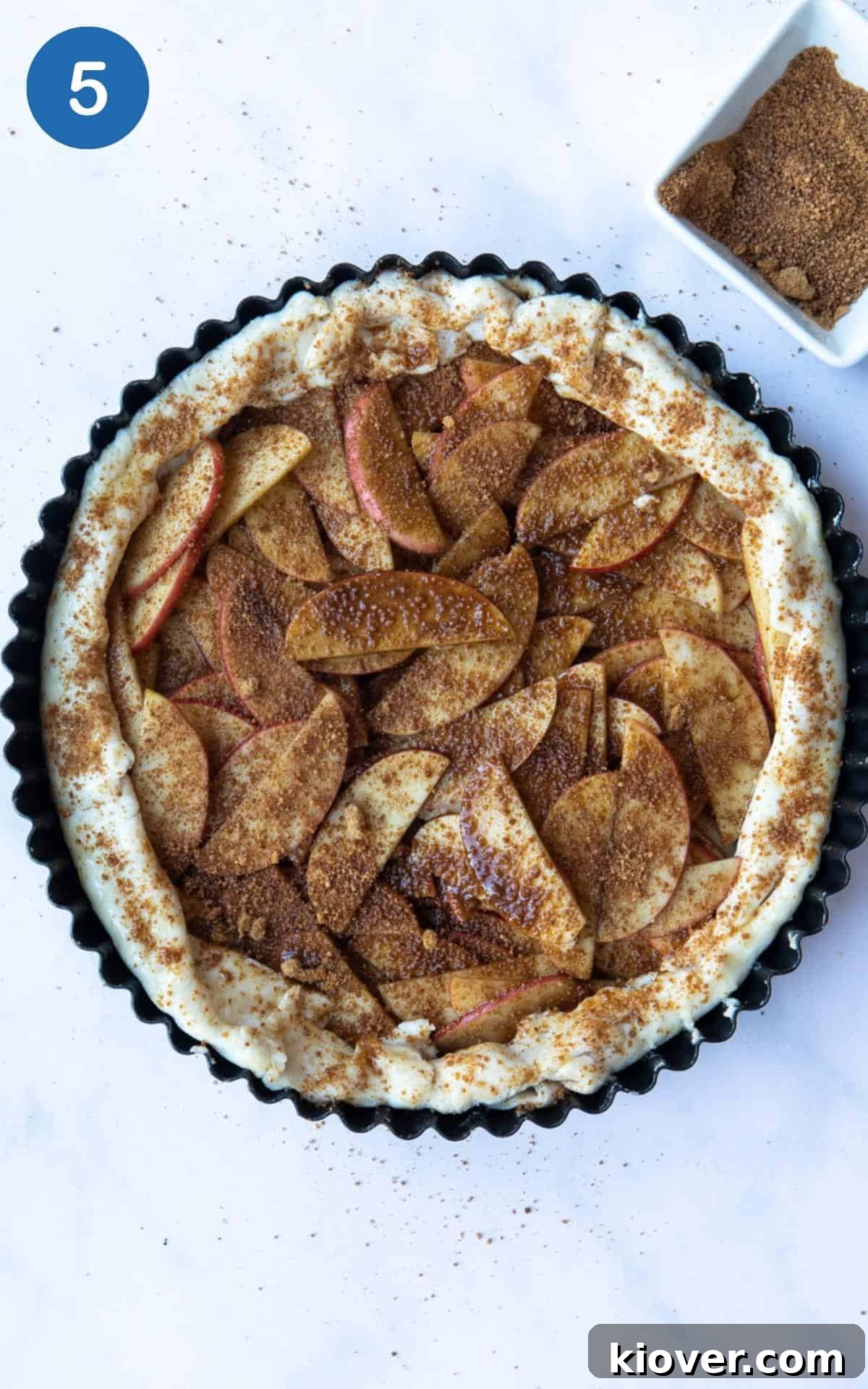 Coconut sugar being added to Puff Pastry Apple Tart before it is cooked.