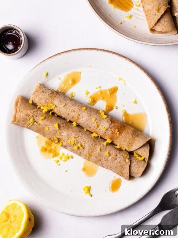 Fluffy Gluten-Free Pancake Recipe for Tender, Quick Breakfast 11 Gluten Free Crepes on a plate drizzled with maple syrup.
