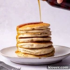 Fluffy Gluten-Free Pancake Recipe for Tender, Quick Breakfast 12 Pouring Maple syrup over gluten free pancakes.