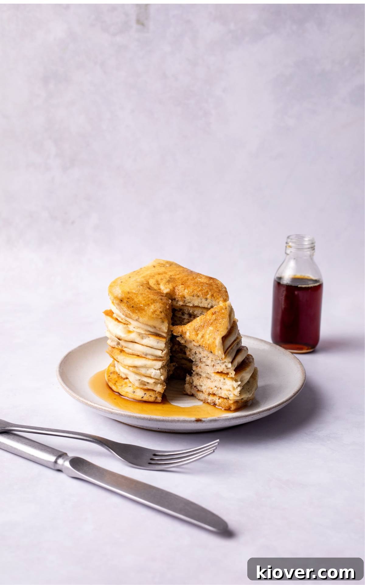 Fluffy Gluten-Free Pancake Recipe for Tender, Quick Breakfast 7 Gluten Free pancakes served on a plate with maple syrup.