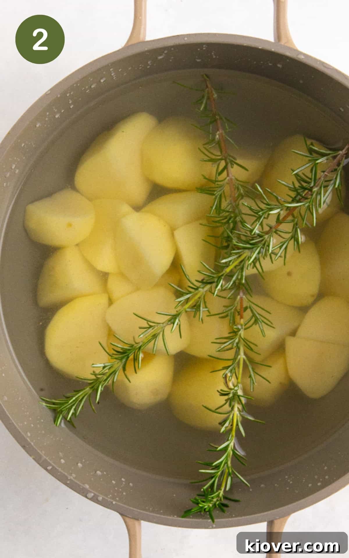 Crispy Air Fryer Roast Potatoes Recipe for Perfect Sides 5 chopped potatoes in a pot of water with rosemary ready to boil.