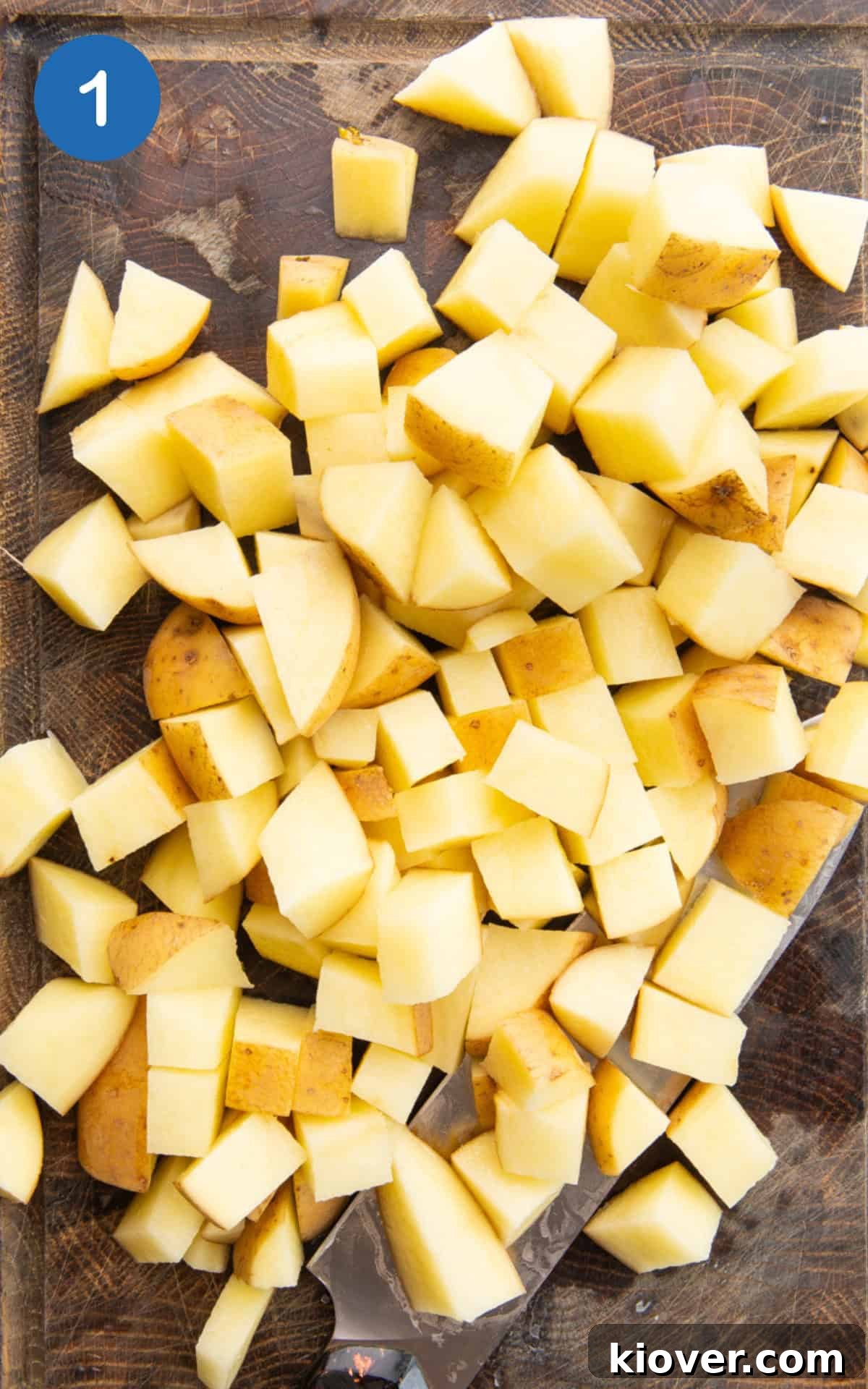 Crispy Potato Cakes Recipe: Fluffy Inside, Golden Outside 4 potatoes chopped into cubes on a wooden cutting board.