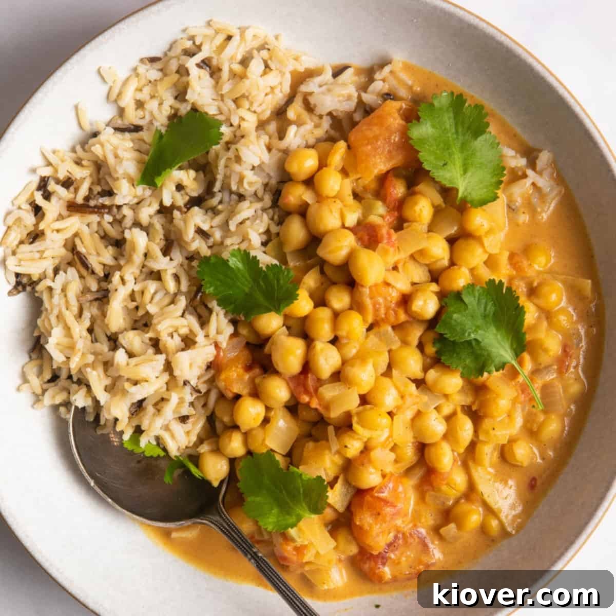 Slow Cooker Chickpea Curry served in a bowl with brown rice and topped with coriander.