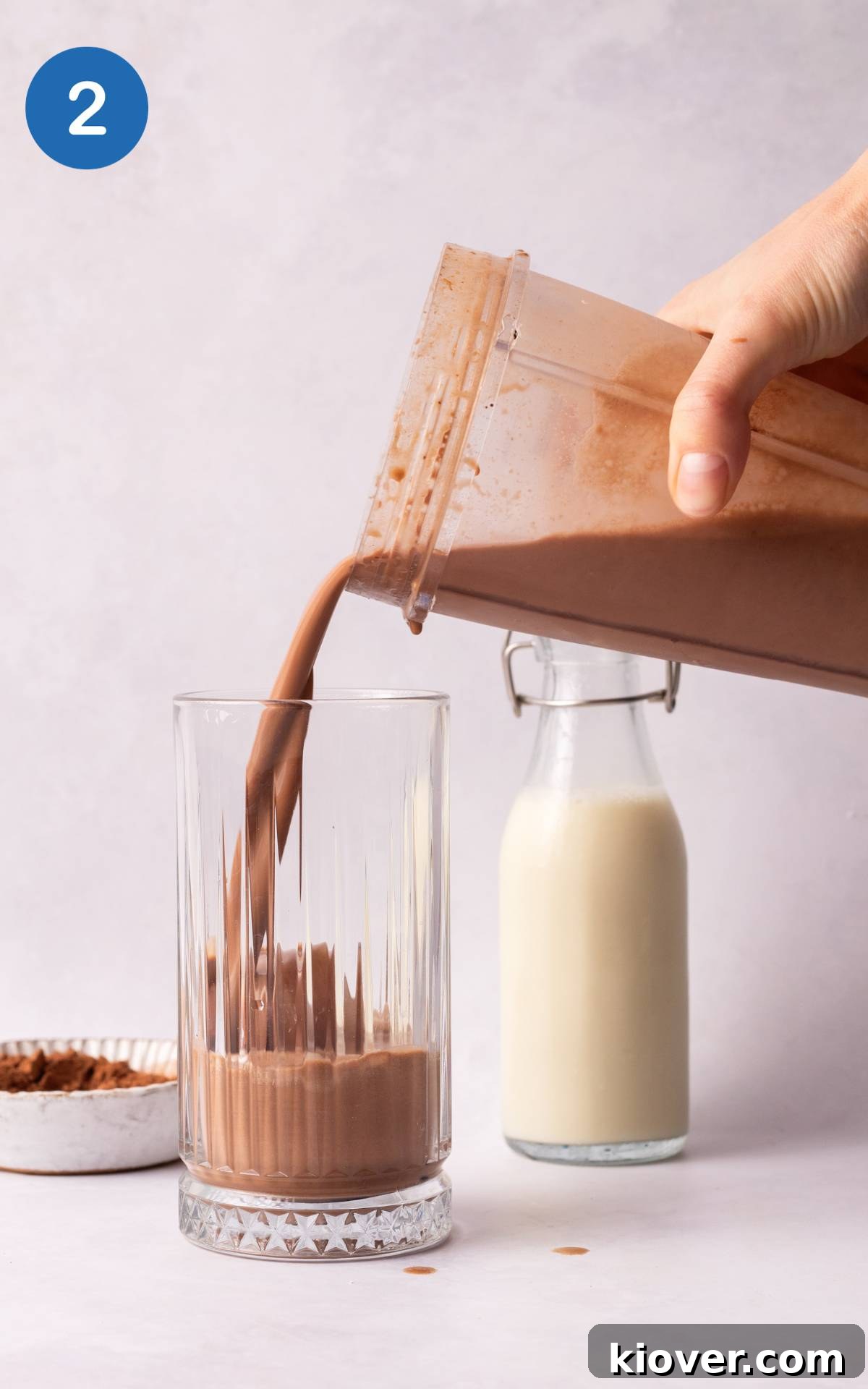 Hand pouring from the blender to a glass.
