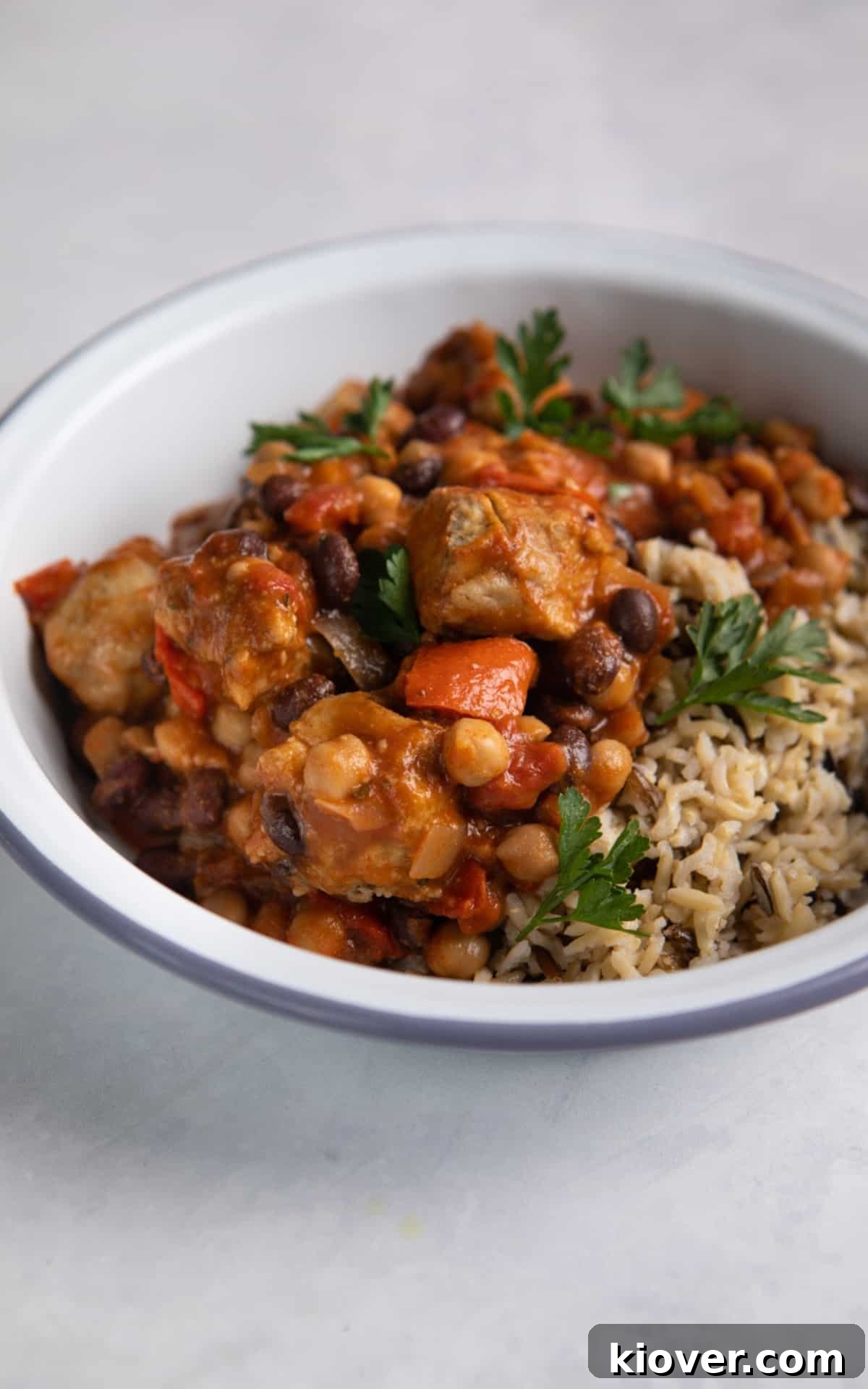 close up of slow cooker sausage casserole with brown rice and parsley.