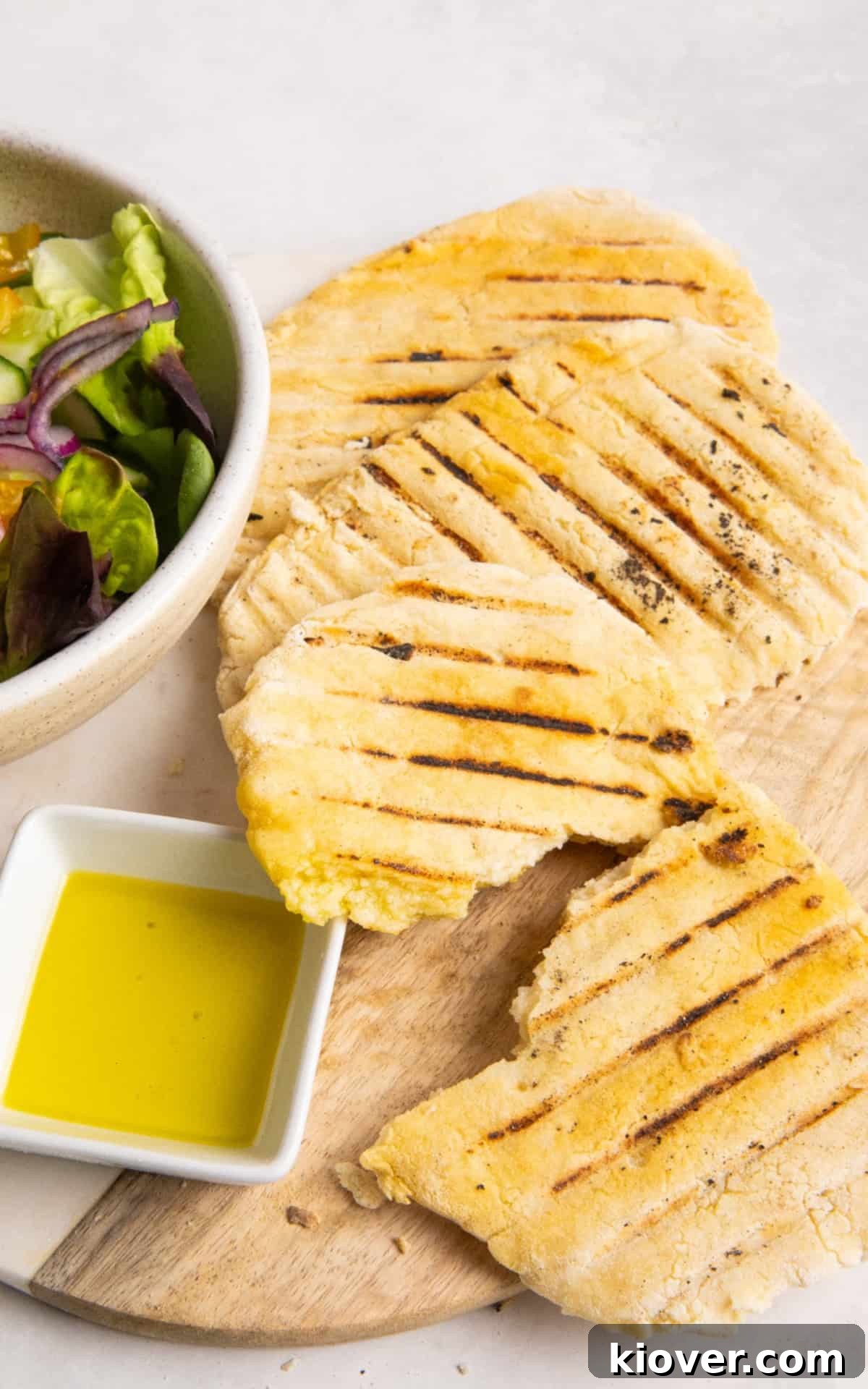 Gluten Free Flatbreads served on a plate with olive oil and a salad.