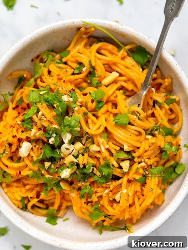 Red Pepper Pasta served in a white bowl with a metal fork