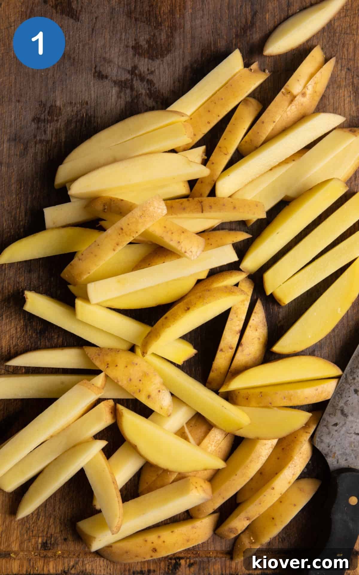 Crispy Air Fryer French Fries: Quick Homemade Recipe 4 potatoes cut lengthways on wooden chopping board.