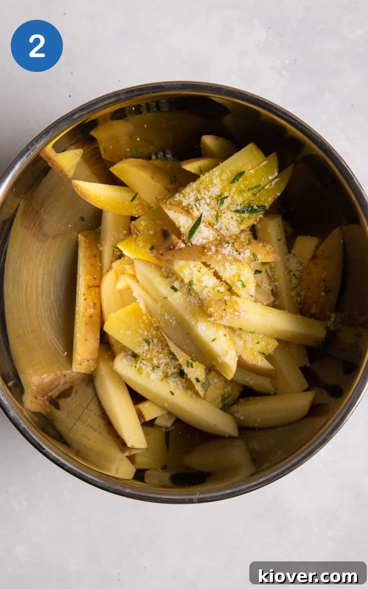 Crispy Air Fryer French Fries: Quick Homemade Recipe 5 pre-cooked chips in large silver mixing bowl with olive oil and salt.