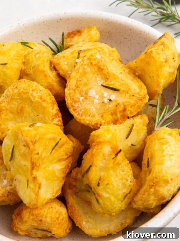 How to Make Homemade Rosemary Salt for Flavorful Cooking 8 air fryer roast potatoes served in a white bowl with fresh rosemary.