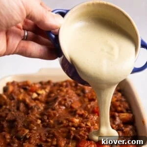 Creamy Vegan Béchamel Sauce Recipe for Pasta & Lasagna 11 white sauce being poured onto of lasagne.