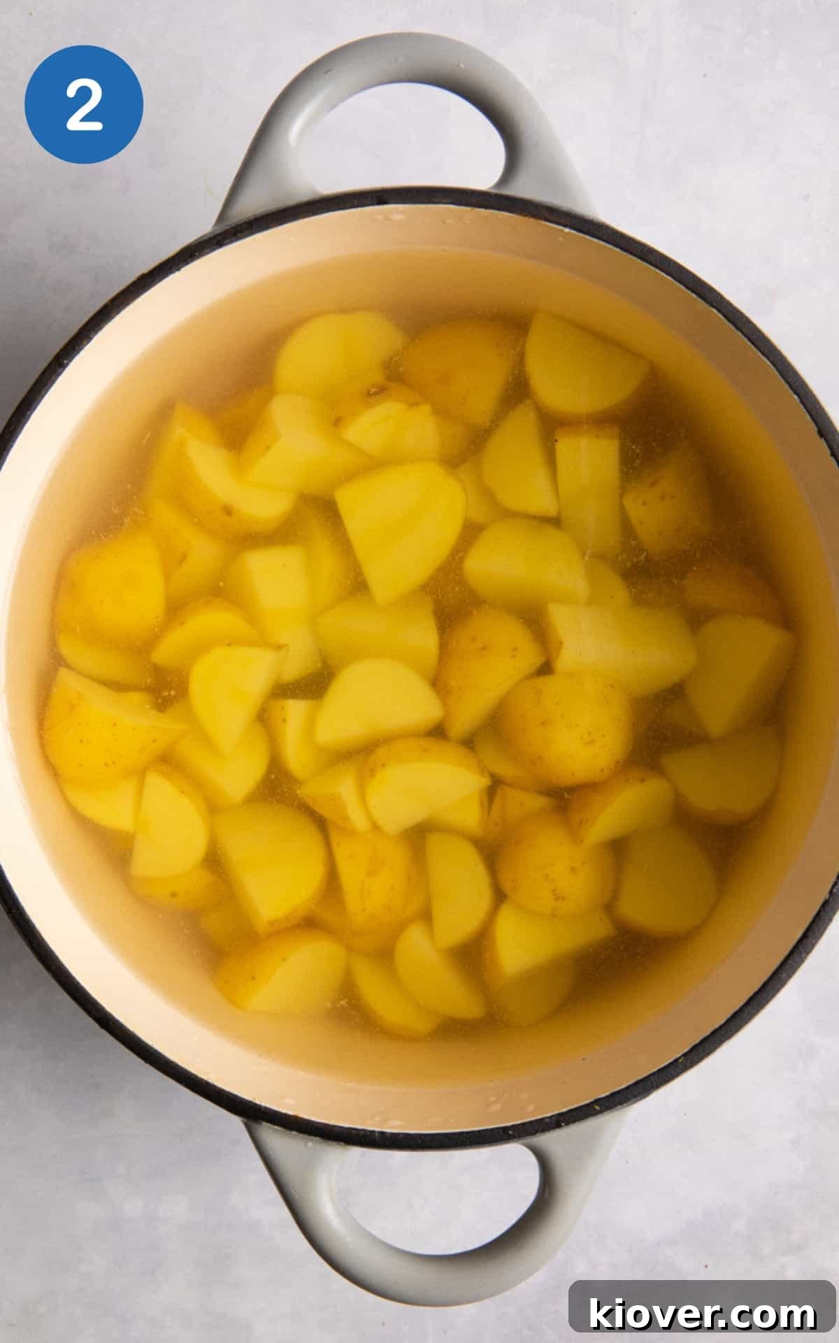 new potatoes being boiled in large cast iron grey pot.