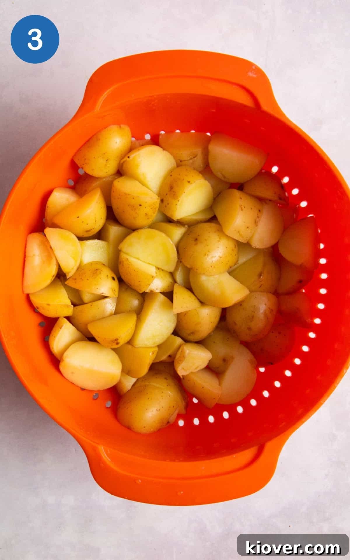 new potatoes being drained in bright orange colander.
