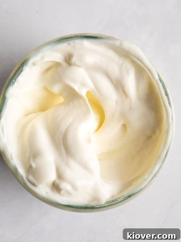 homemade vegan mayonnaise in a jar served on a white background.