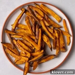 sweet potato fries on white plate with orange rim.