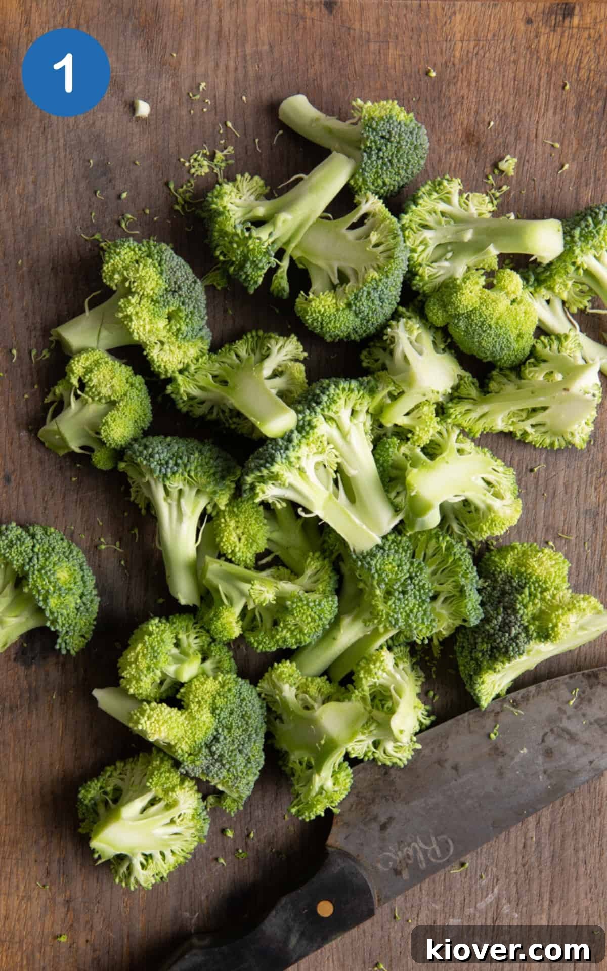 Crispy Air Fryer Broccoli Recipe — Quick Dinner Side 4 Broccoli chopped on dark wooden chopping board.