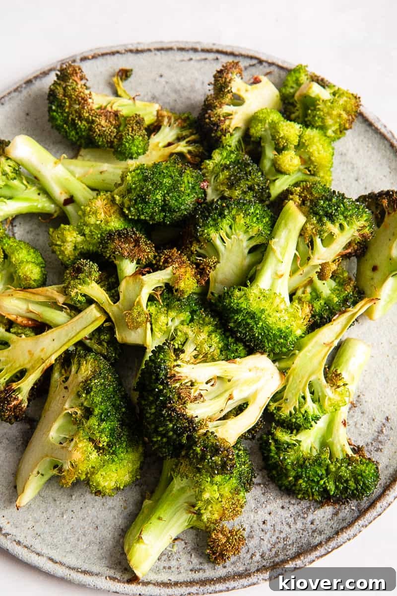 Crispy Air Fryer Broccoli Recipe — Quick Dinner Side 7 Broccoli on on grey plate on white surface.