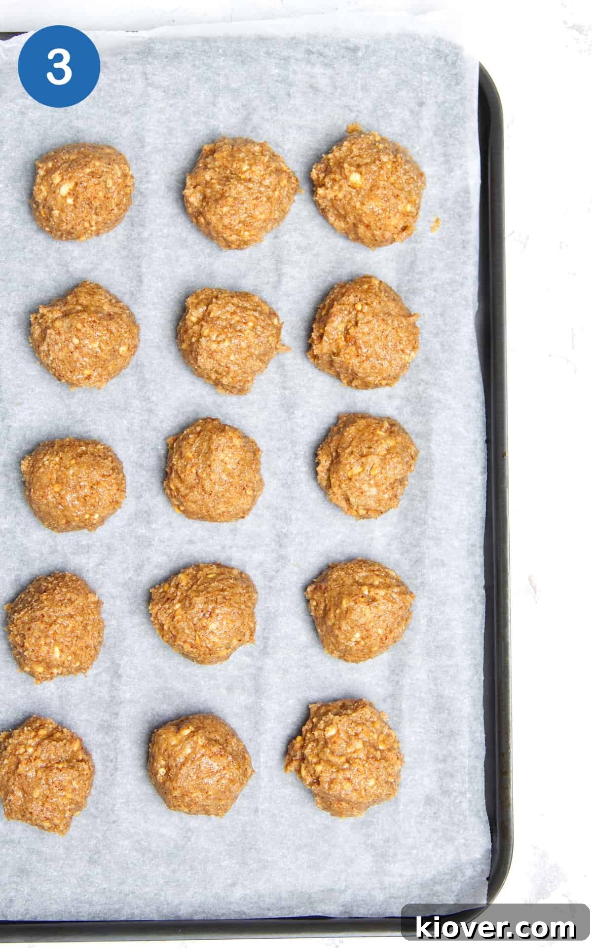 No-Bake Peanut Butter Protein Balls for Snacks & Desserts 6 peanut butter balls on a tray lined with baking paper.