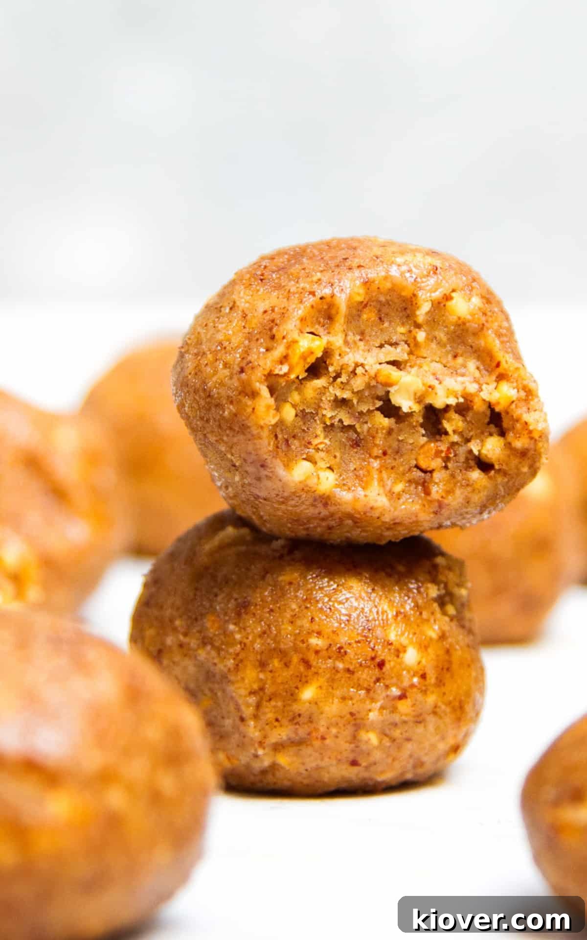 No-Bake Peanut Butter Protein Balls for Snacks & Desserts 8 Peanut butter balls stacked on a white surface.