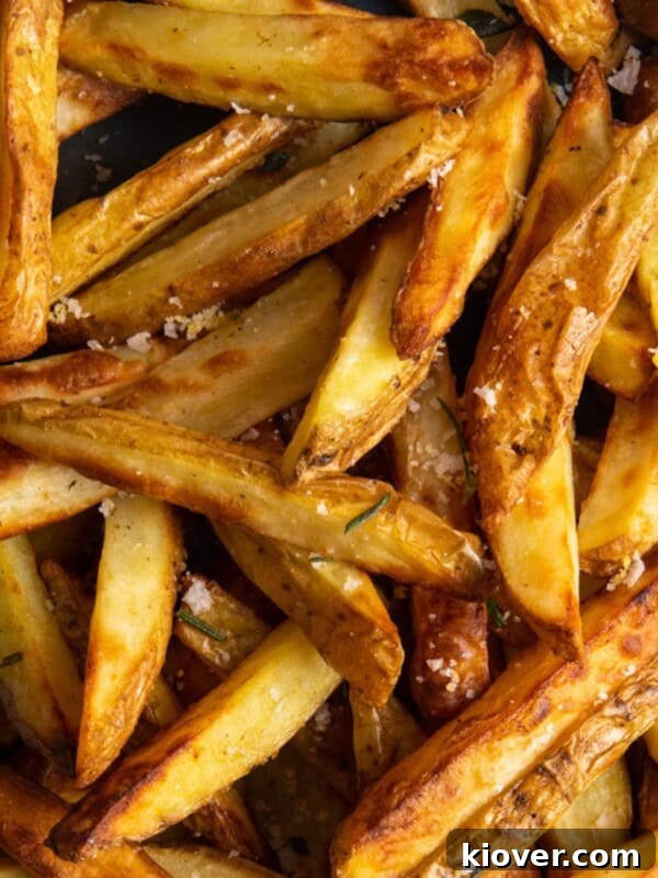 Crispy Air Fryer Smashed Potatoes with Garlic and Parmesan 8 close up shot of air fryer chips with salt on them.