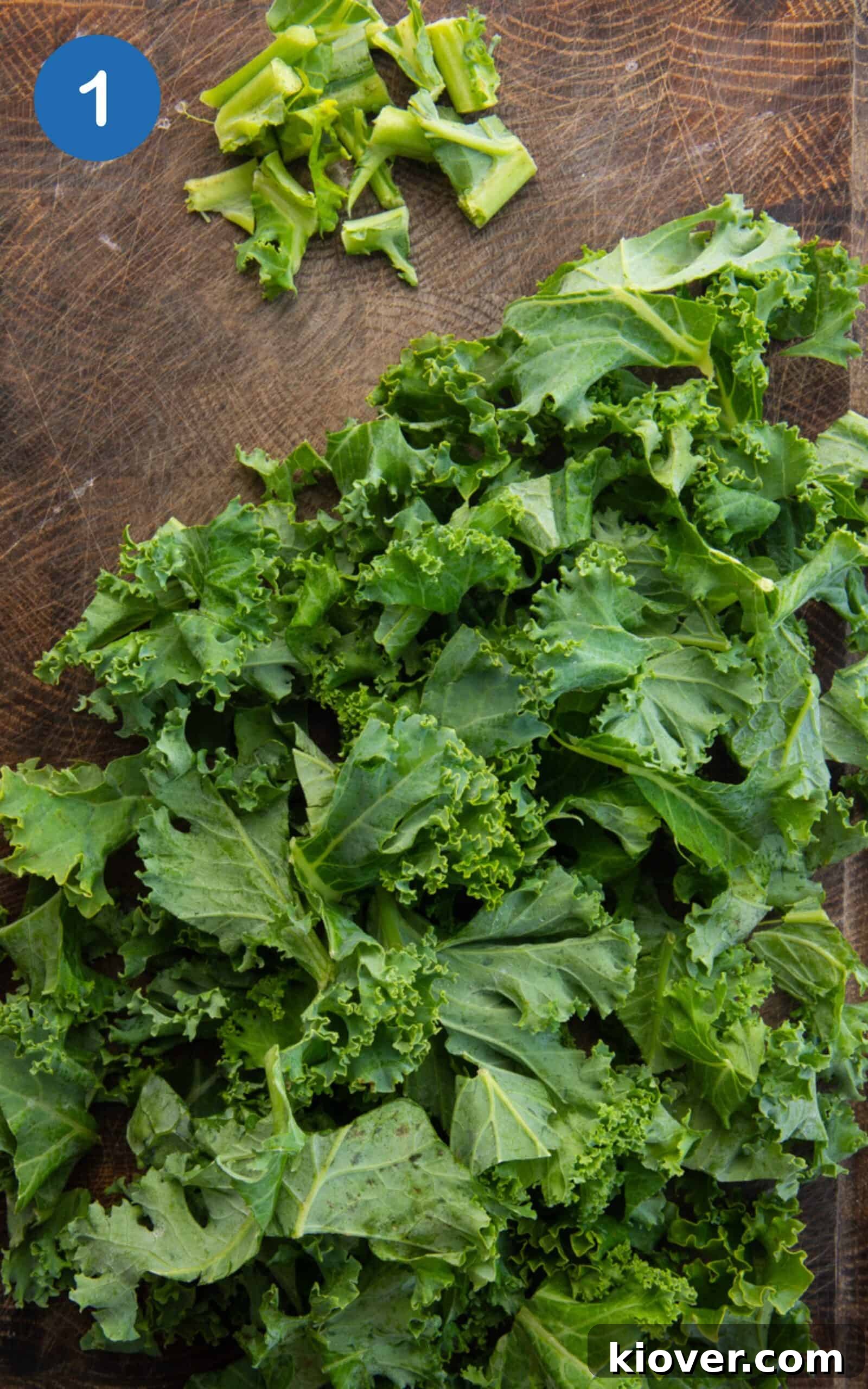 chopped kale leaves on a wooden cutting board.