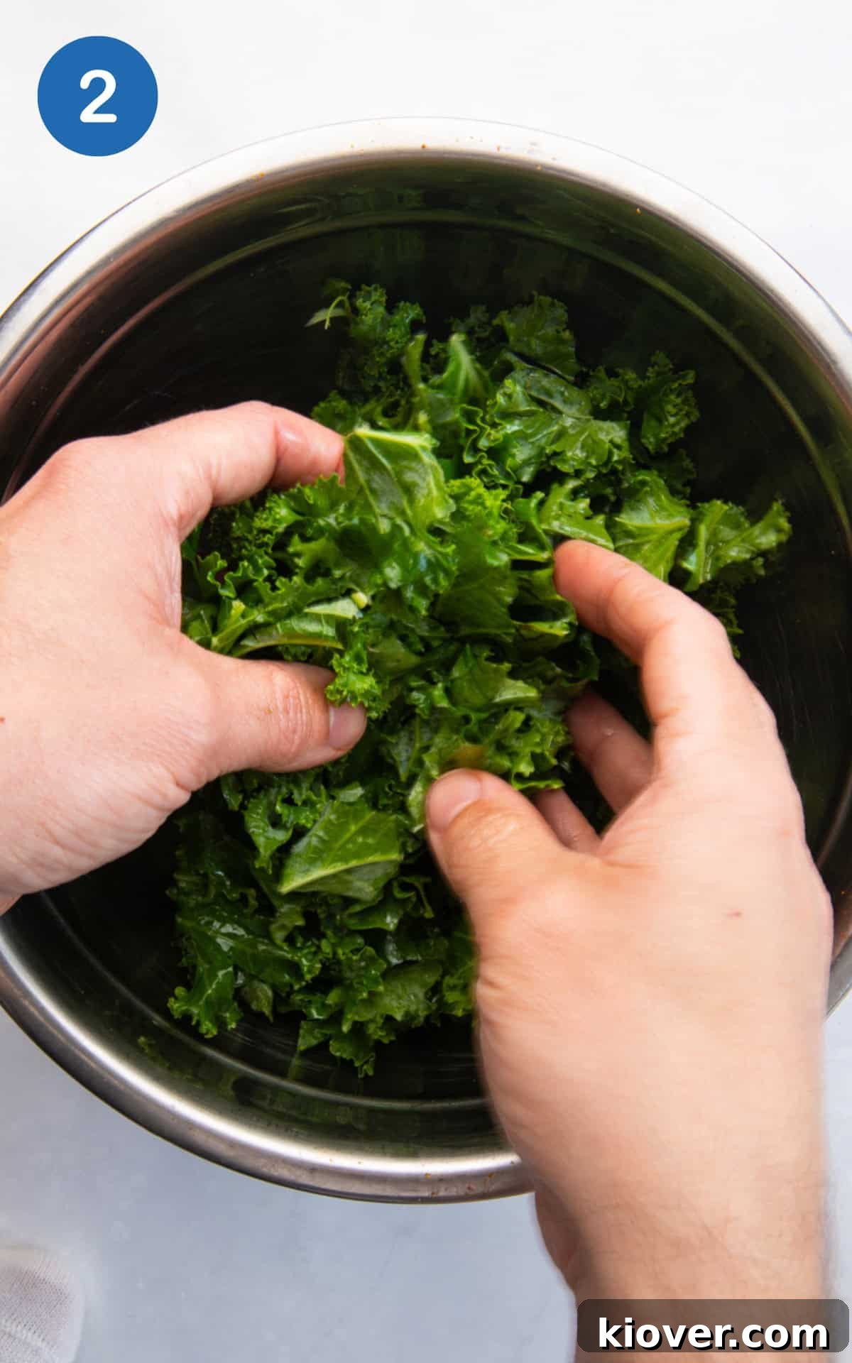 mixing kale with olive oil and salt.