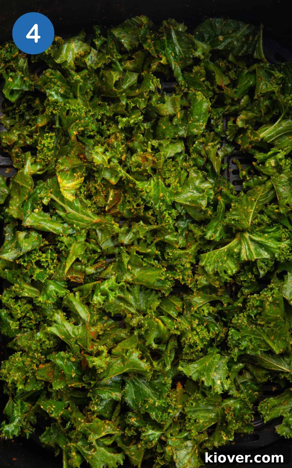 seasoned kale leaves in the air fryer basket.