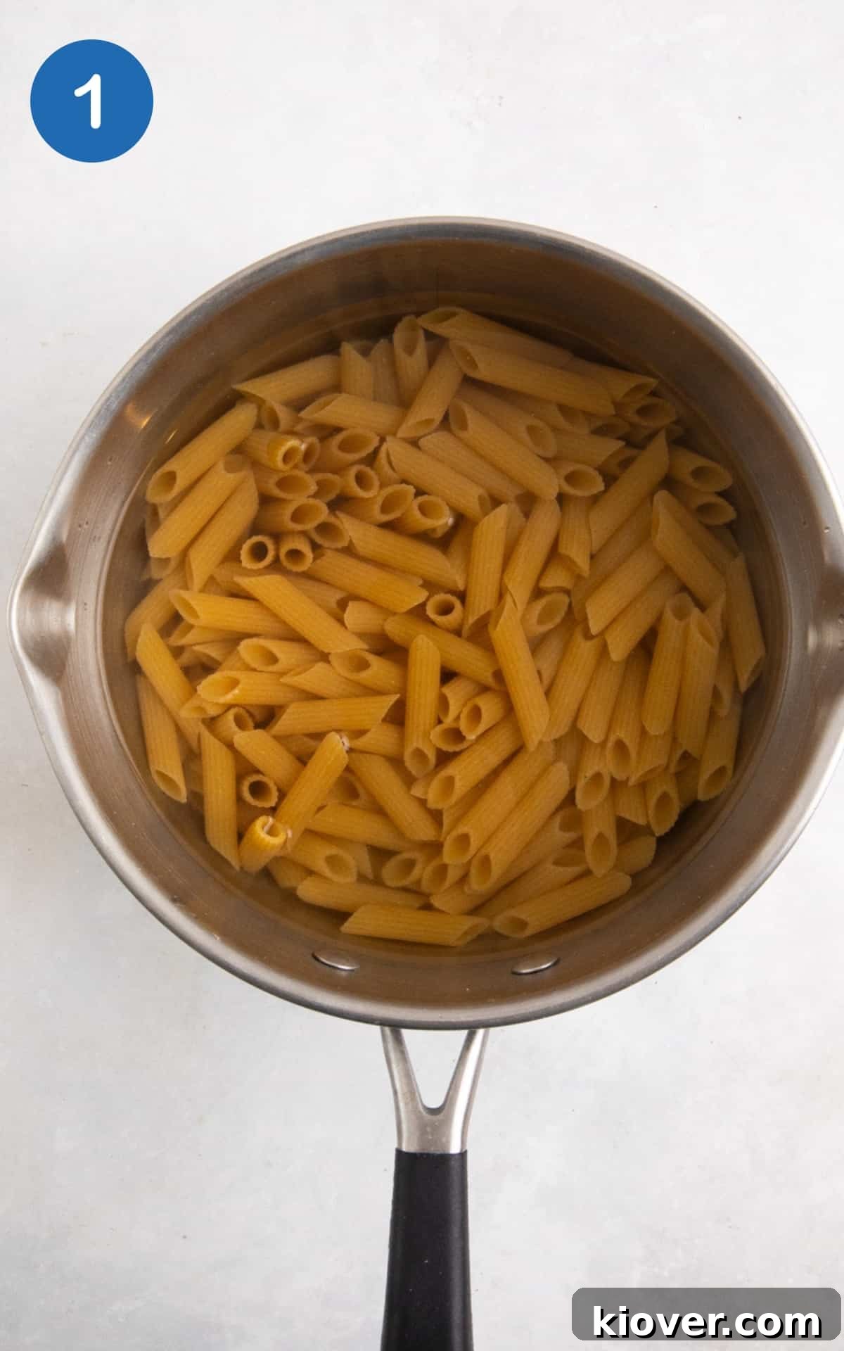 boiling penne pasta in a large silver pot.