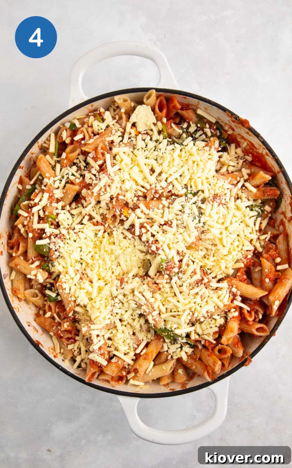 tuna pasta bake in a large white casserole dish topped with cheese for baking.