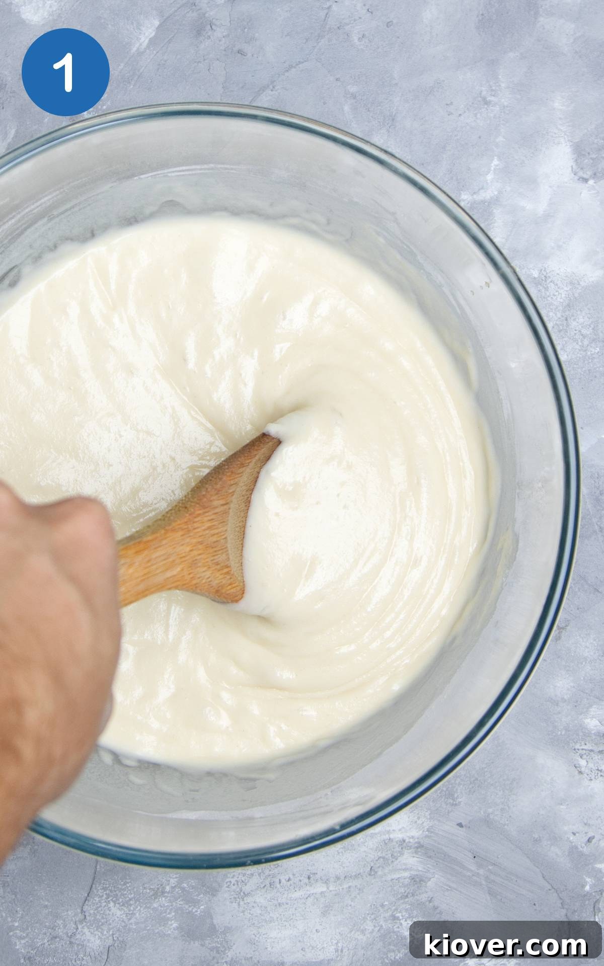 batter in transparent mixing bowl on grey surface.