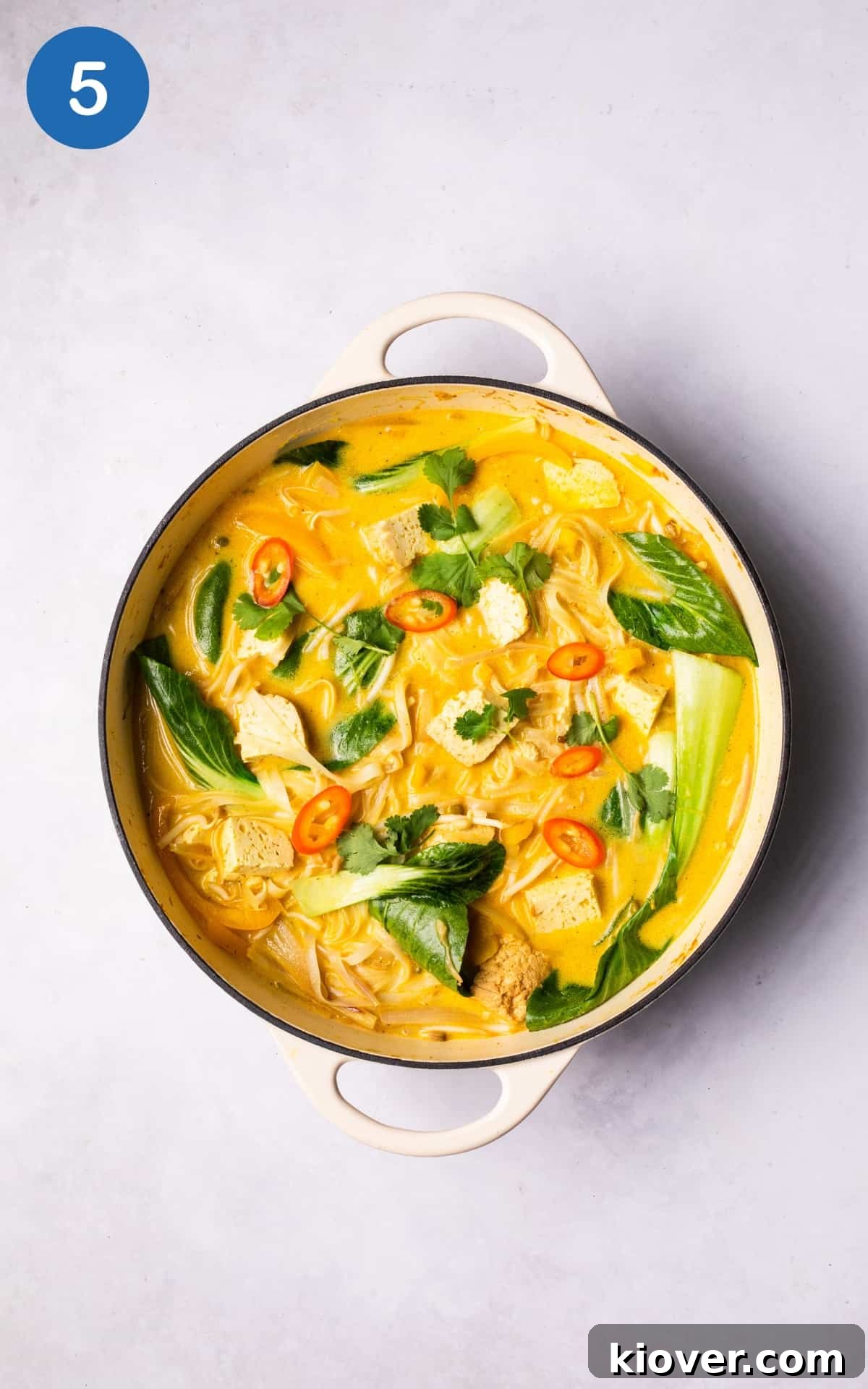 Creamy Vegan Laksa Recipe: Flavorful Plant-Based Coconut Curry Soup 8 adding lime juice and fresh coriander to vegan laksa.