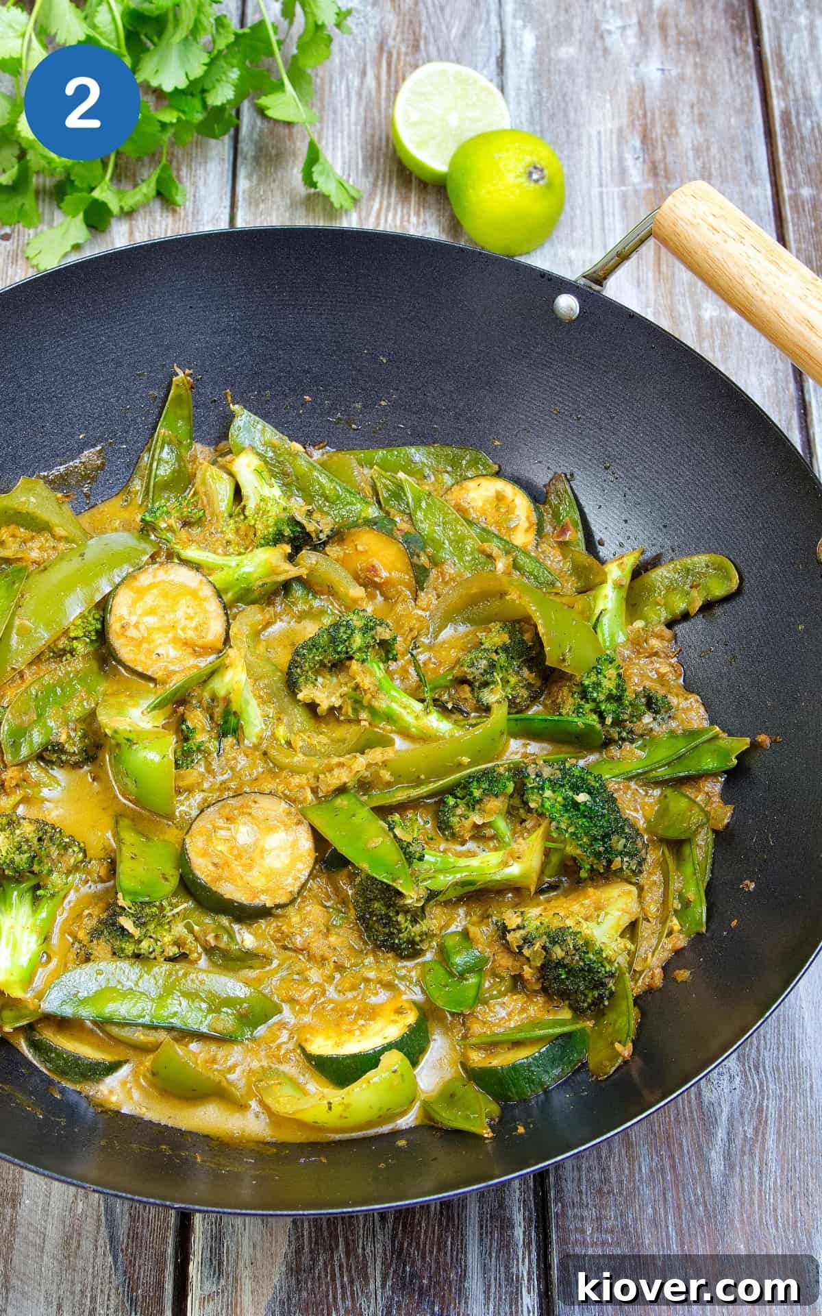 Ingredients to make Vegetable Thai Green Curry with sauce in a wok.