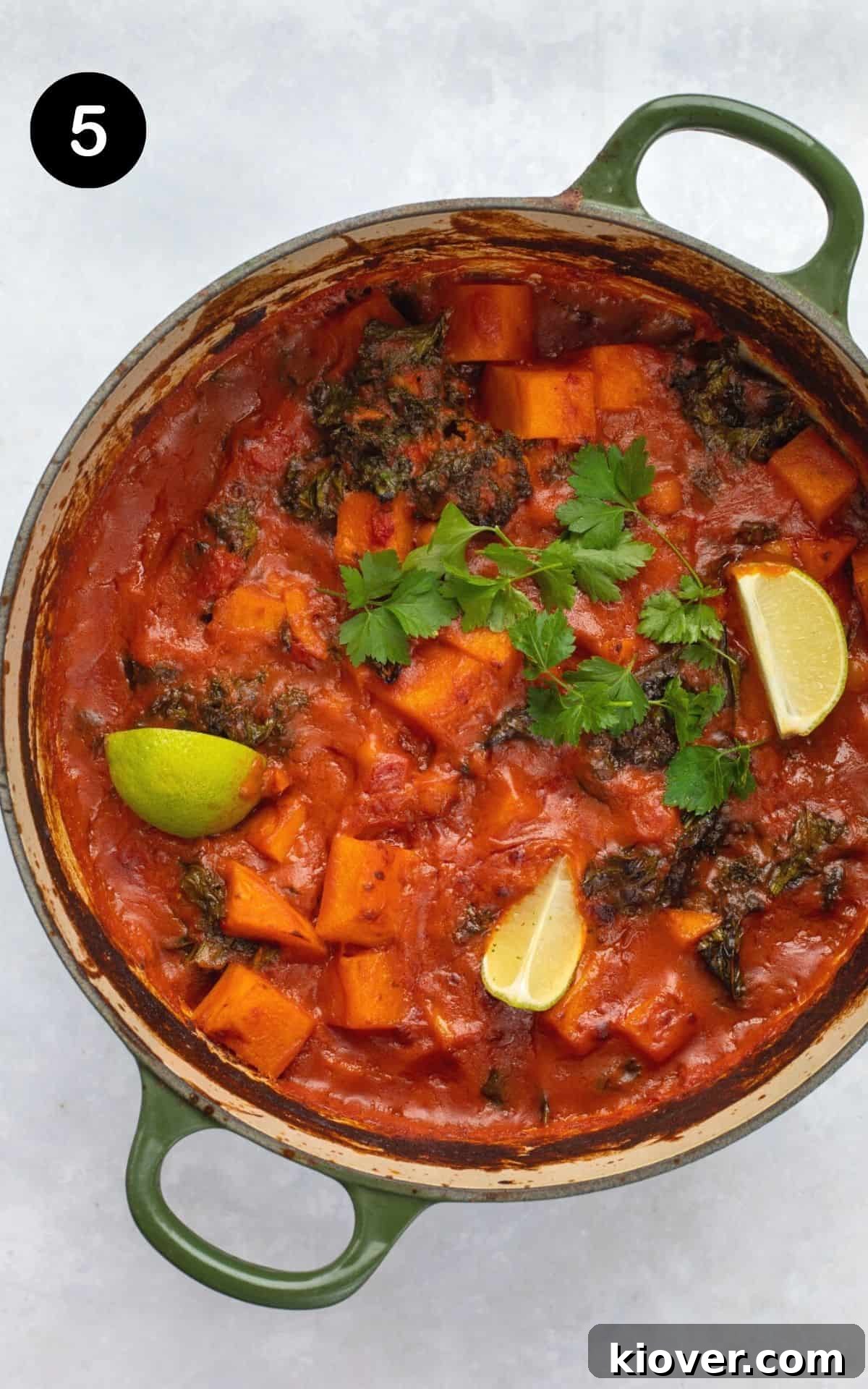 baked sweet potato curry in a pot served with lime and coriander.