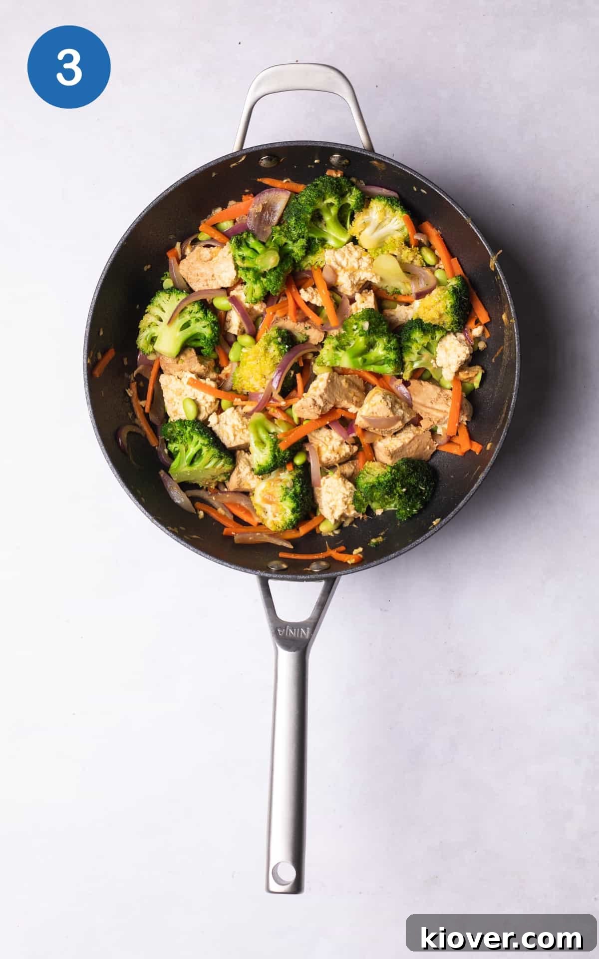combining the vegetables and miso paste in a wok pan.