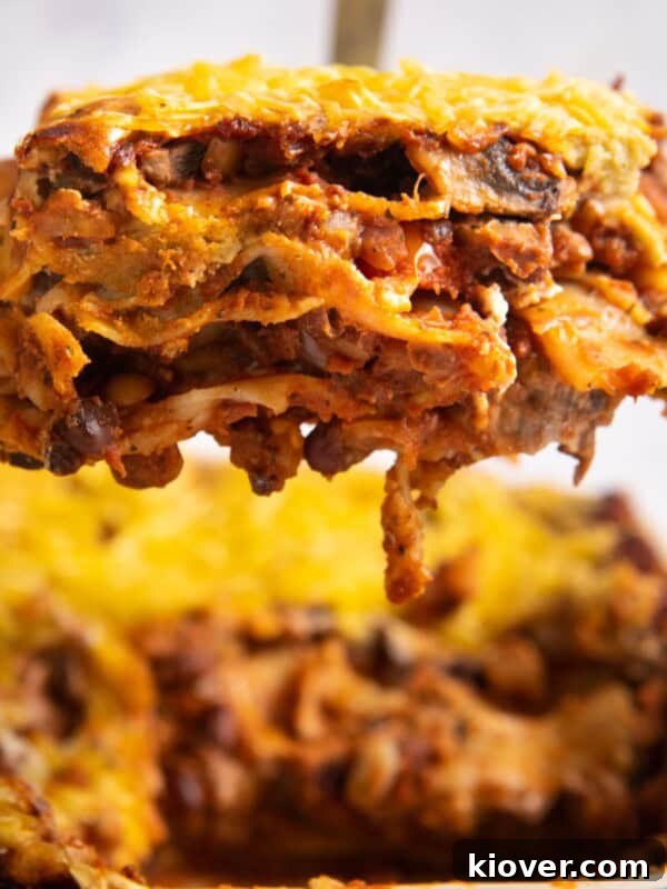 lasagne slice being lifted from baking dish full of lasagne.