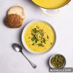 cauliflower soup served with bread rolls and pumpkin seeds.