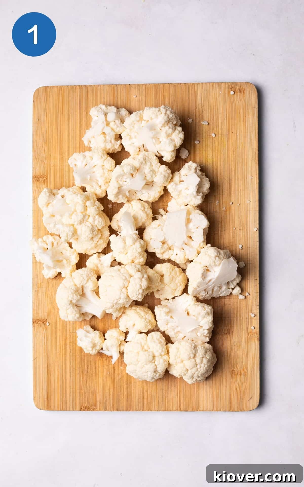Crispy Air Fryer Cauliflower Recipe for a Perfect Side Dish 4 cauliflower cut into florets on a wooden cutting board.
