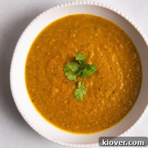 43 Gluten-Free Vegan Recipes for Everyday Meals and Desserts 9 Carrot & Coriander Soup served in a white bowl with coriander on top.