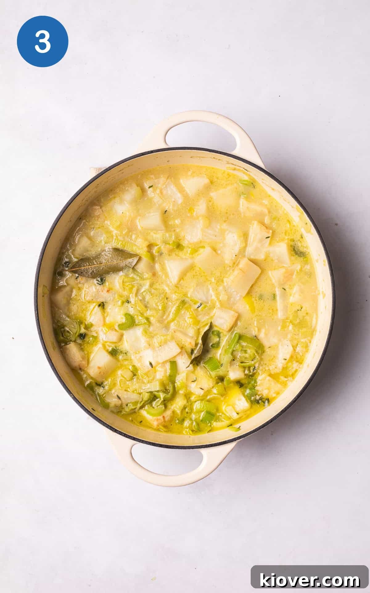 Creamy Celeriac Soup Recipe with Garlic and Thyme 6 adding the crushed garlic, celeriac, bay leaves, fresh thyme, pepper, vegetable stock, and cream to the pan.