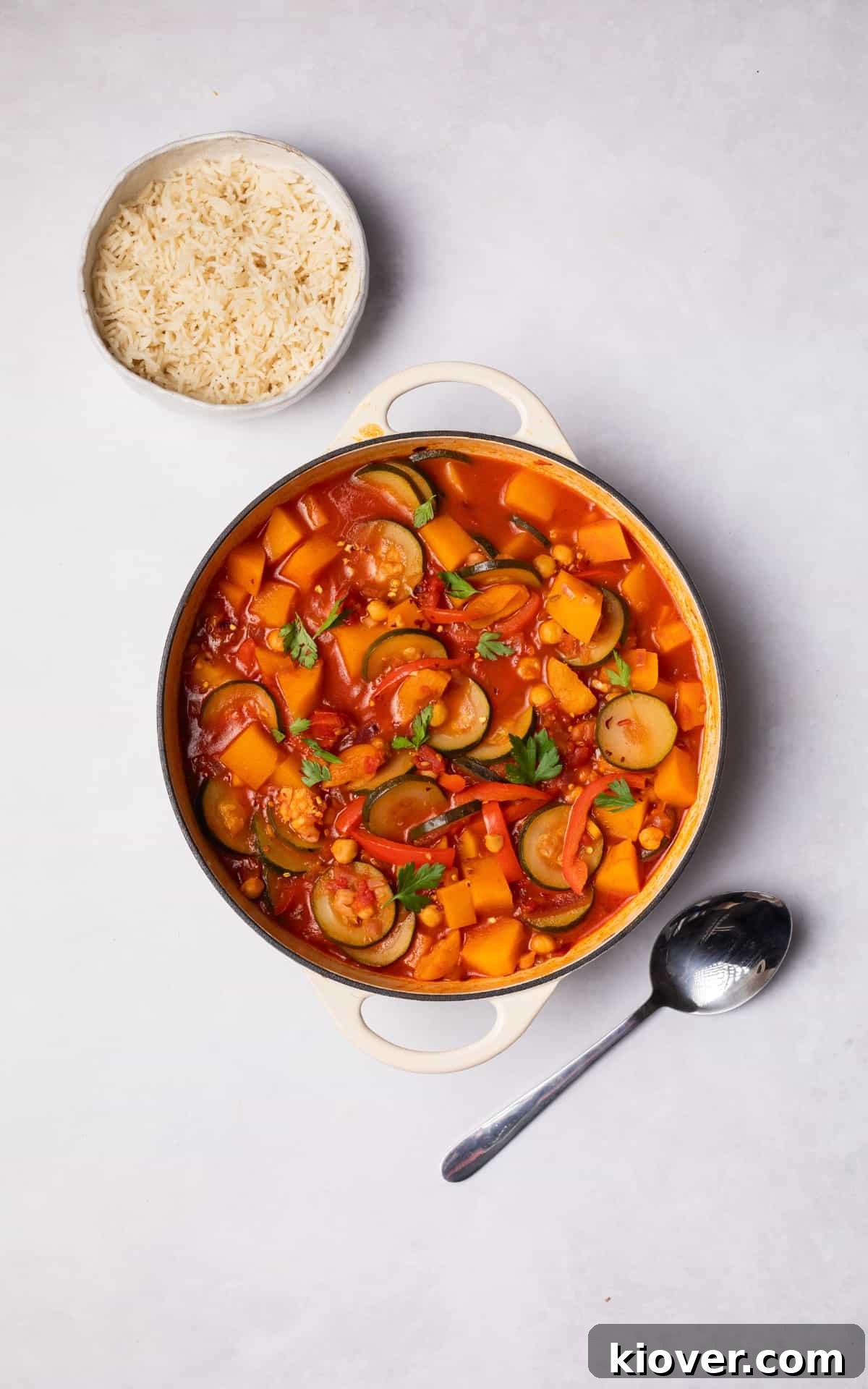 Moroccan Vegetable Tagine Recipe: Flavorful Slow-Cooked Veg Stew 8 Vegetable Tagine in a pot with a bowl of rice next to it.