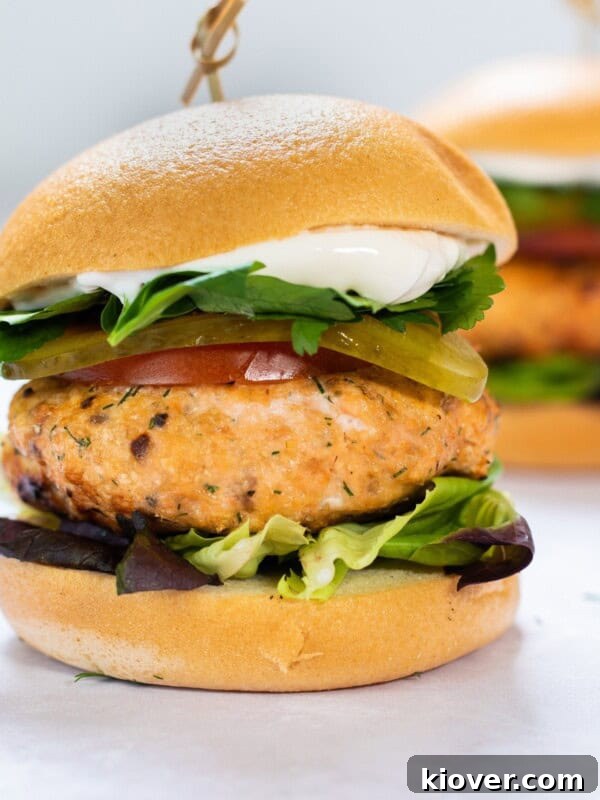 Creamy Salmon Noodle Bowl with Lemon and Dill 14 salmon burger with bun and lettuce on white background.