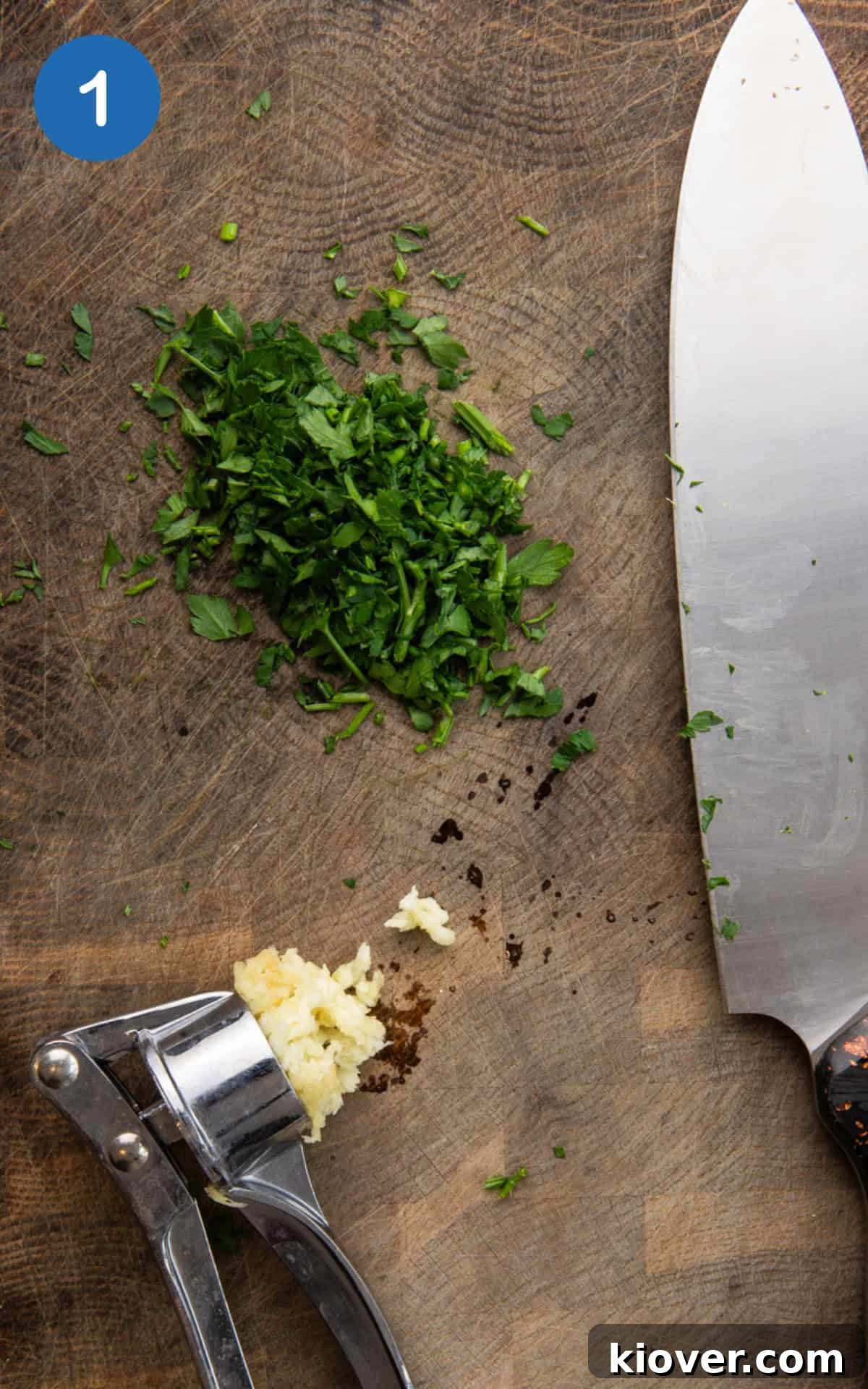chopped parsley and garlic on a wooden cutting board.