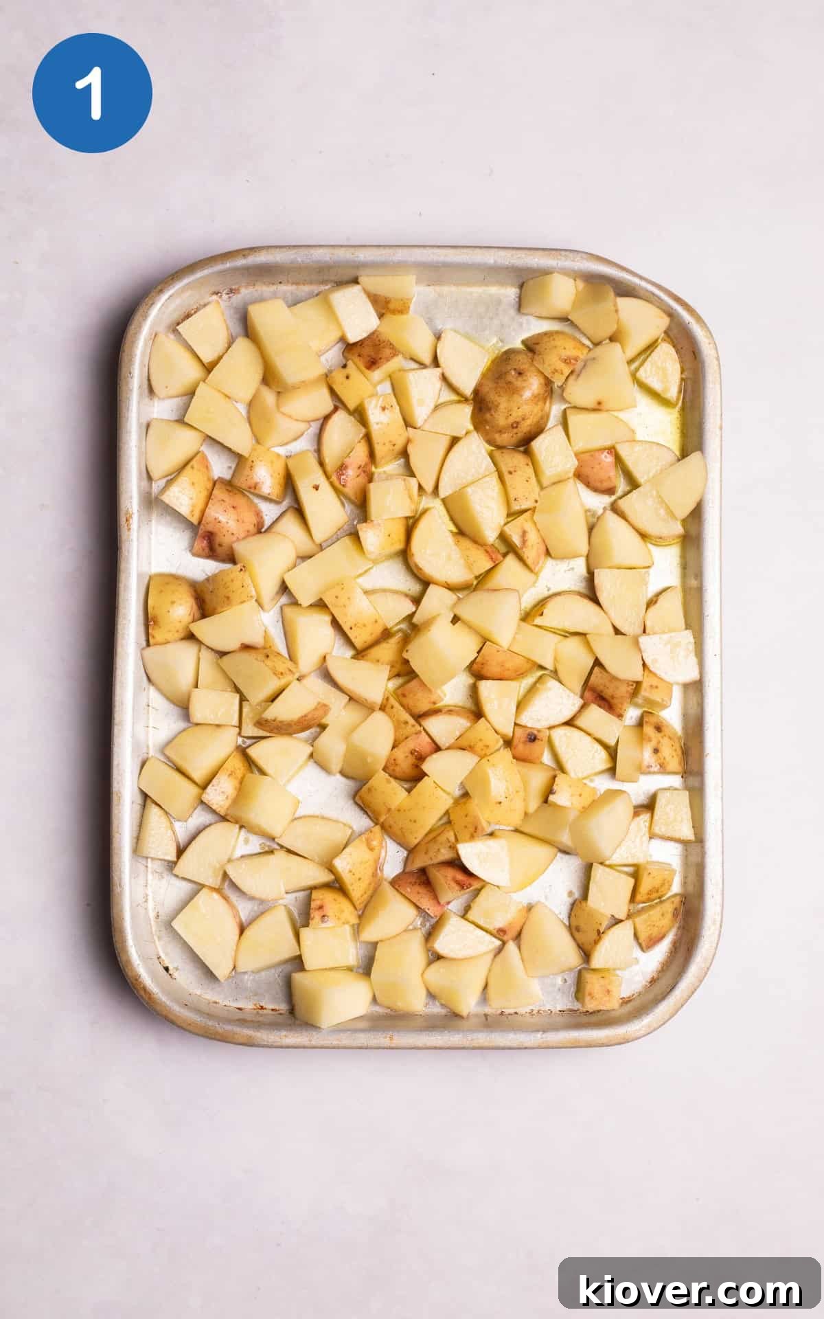potatoes coated with olive oil in a pan.