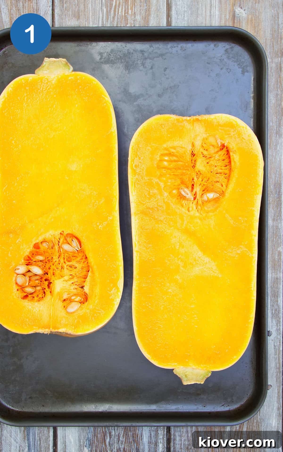 chopped butternut squash in half on a baking tray.