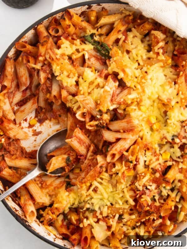 tuna pasta bake in a large white casserole dish served with a spoon.
