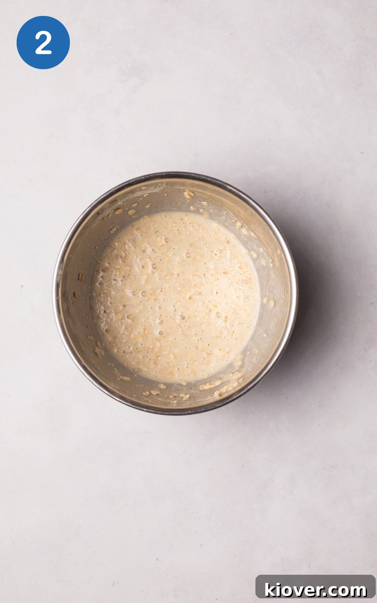 Creamy Baked Oats Recipe for Breakfast and Meal Prep 5 Combining protein powder, baking powder, milk, and oats with banana in a bowl.