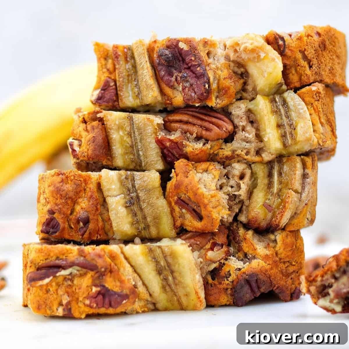 slices of banana bread on top of beach other on white surface with white background.