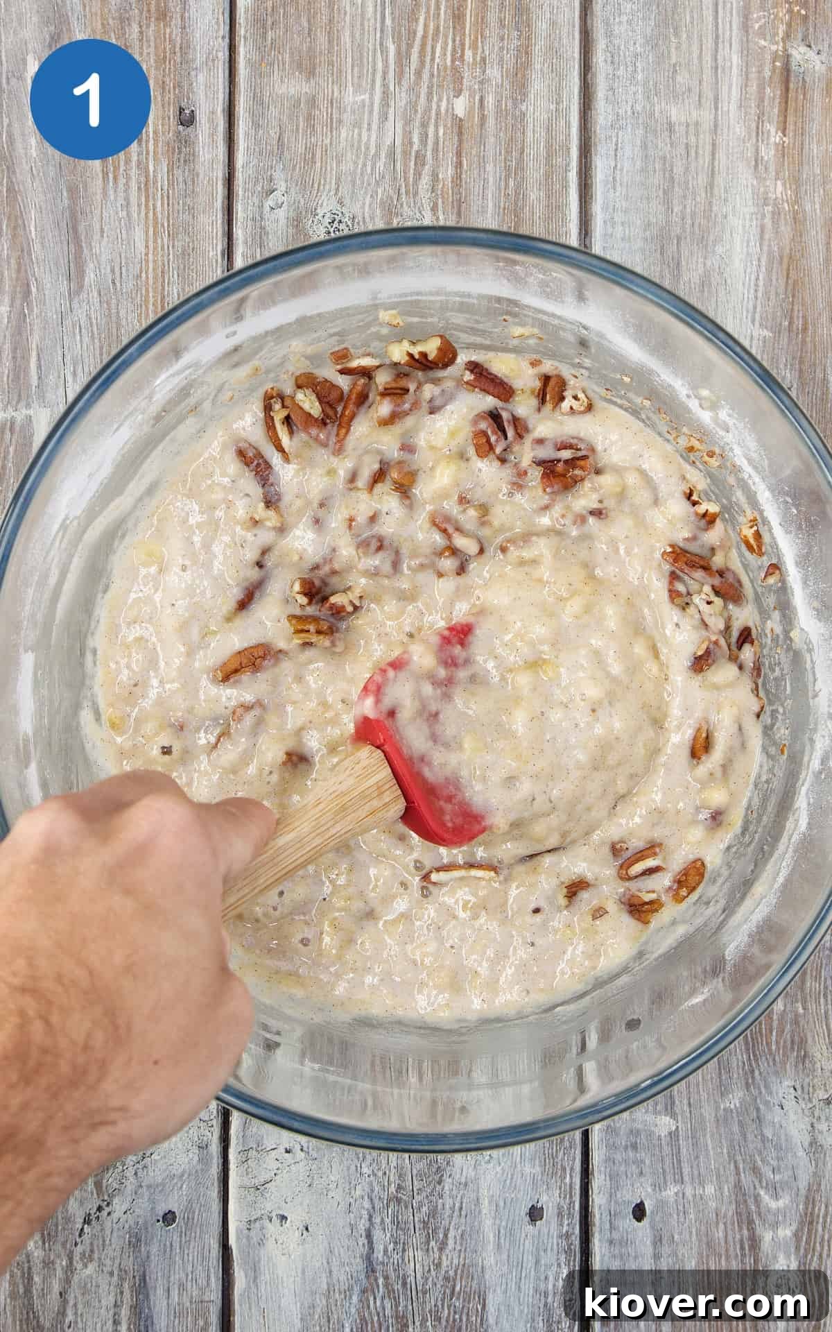 ingredients to make banana bread in transparent mixing bowl on wooden surface.